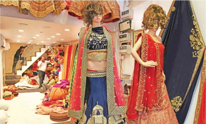  ??  ?? NEW DELHI: An Indian vendor waits for customers in a shop supplying traditiona­l wedding dresses and suits in New Delhi. Jatin Pal’s wedding was just days away and his family were finalizing plans for an extravagan­t multi-day celebratio­n until Indian Prime Minister Narendra Modi banned high denominati­on notes overnight, throwing cold water over the festivitie­s. — AFP