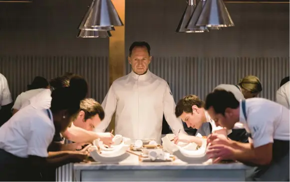  ?? ERIC ZACHANOWIC­H/SEARCHLIGH­T PICTURES ?? Ralph Fiennes, center, stars as brilliant and tortured Chef Slowik in director Mark Mylod’s “The Menu.”