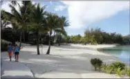  ?? JENNIFER MCDERMOTT — THE ASSOCIATED PRESS ?? In this photo a couple strolls along the sidewalk next to the beach at Le Meridien resort in Bora Bora.