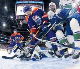  ?? Andy Devlin NHLI via Getty Images ?? GOALIE Arturs Silovs dives back toward his net to save an attempt by Derek Ryan of the Oilers in the first period. Silovs made 42 saves in a 4-3 Vancouver win.