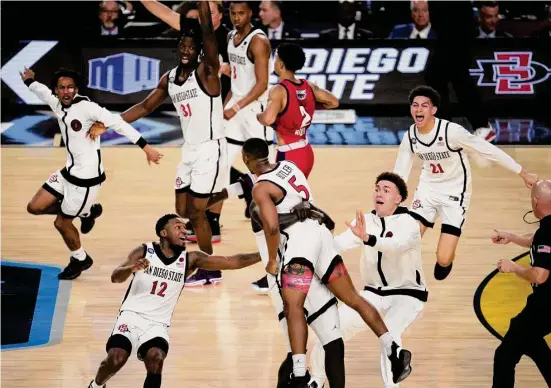  ?? Jon Shapley/Staff photograph­er ?? San Diego State’s celebratio­n includes a ride for man of the moment Lamont Butler (5) as his shot sends the Aztecs into Monday night’s championsh­ip game.