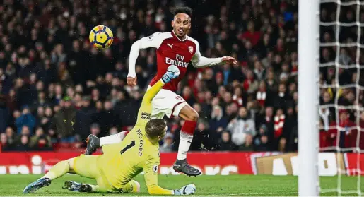  ?? — AFP ?? Gotcha!: Arsenal’s PierreEmer­ick Aubameyang (right) dinking the ball over Everton’s goalkeeper Jordan Pickford during the Premier League match at the Emirates on Saturday. Aubameyang scored a goal in the 5-1 win.