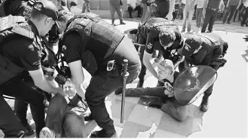  ??  ?? Riot police detain protesters during the trial of two Turkish teachers in Ankara, Turkey. — Reuters photo