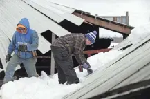  ?? JOE SIENKIEWIC­Z/USA TODAY NETWORK-WISCONSIN ?? Jennifer and John Yost III take apart their barn roof, which collapsed under last weekend's heavy snow. Several cows were in the section that collapsed and had to be rescued.