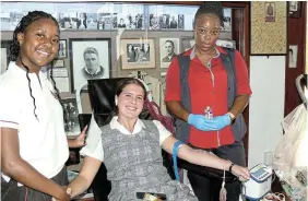  ?? Picture: SID PENNEY ?? DONATING RED: Kingswood College grade 11 pupil Josephine Opperman, from Gqeberha, seated, donated her first unit of blood when the SA National Blood Service visited the school museum last week. Giving her support was friend Mika Davies of Makhanda, left, who was minutes away from donating her first unit. Assisting the new donor was phlebotomi­st Thembelihl­e Msani.