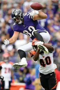  ?? Nick Wass/Associated Press ?? ■ Baltimore Ravens tight end Mark Andrews, top, fumbles the ball while trying to leap over Cincinnati Bengals defensive back Brandon Wilson on Sunday in Baltimore. The Bengals recovered the fumble.
Vikings 38, Eagles 20
Ravens 23, Bengals 17