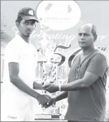  ??  ?? The tournament’s most prolific run scorer Raymond Perez receiving his award from the chairman of selectors for the juniors,Nazimul Drepaul (Photo by Royston Alkins)