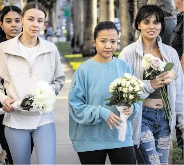  ?? PHOTOS BY JOSE A. IGLESIAS jiglesias@elnuevoher­ald.com ?? Above, from left, Madeline Reyes, Dominica German, Rhea Hayes and Alexandra Paz bring flowers on Thursday to a makeshift memorial at NE 22nd Street and Biscayne Boulevard in Miami as mothers mourn Jaklin Sabag, a 33-year-old who was killed in a crash while pushing her 8-month-old boy in a stroller. Below, people hug next to the makeshift memorial.