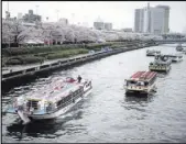  ?? Eugene Hoshiko The Associated Press ?? Boats float along the Sumida River with Tokyo’s cherry blossoms in full bloom.