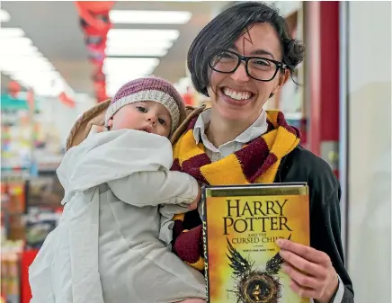  ?? PHOTO: FAIRFAX NZ ?? Avid Harry Potter fan Sara Epperson and her 13-month-old daughter Milly, lined up at Whitcoulls South City, Christchur­ch, to grab a copy of the new title and the Cursed Child. Harry Potter