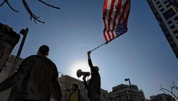  ?? ?? Oded Balilty / Associated Press A family member of Israeli hostages held by Hamas in Gaza waves the U.S. flag at a protest calling for their return in Tel Aviv, Israel, Tuesday.