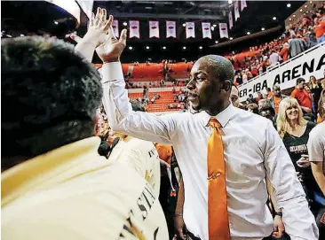  ?? [PHOTO BY NATE BILLINGS, THE OKLAHOMAN] ?? Oklahoma State coach Mike Boynton gives a fan a high five after the Bedlam men’s college basketball game against Oklahoma on Saturday in Stillwater. OSU won 83-81 in overtime.