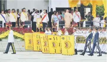  ??  ?? His Majesty Sultan Muhammad V (fourth left) gives the royal salute during the Trooping the Colour ceremony. — Bernama photo