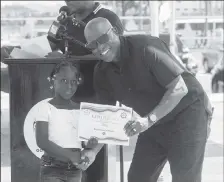  ?? ?? Director of Sport Steve Ninvalle hands over a Certificat­e of Participat­ion to one of the youngest participan­ts in the NSC’s ‘Easter Learn to Swim’ Programme.