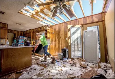  ?? Arkansas Democrat-Gazette/STEPHEN B. THORNTON ?? Patty Elmore walks through the debris in her brother’s house Wednesday in Higginson, the morning after a tornado hit the town in White County, cutting a 1.5-mile path.