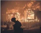  ?? NOAH BERGER/AP ?? Flames from a wildfire consume a residence near Oroville, Calif., last July.