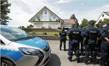  ??  ?? Polizisten sammeln sich zum Einsatz am Wohnhaus des ermordeten Walter Lübcke in Wolfhagen-Istha bei Kassel.