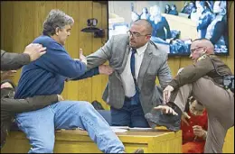 ?? AP ?? Randall Margraves (left), father of the victims of former Michigan State University sports doctor Larry Nassar (bottom right), lunges at the latter in Eaton County Circuit Court in Charlotte, Michigan on Friday.