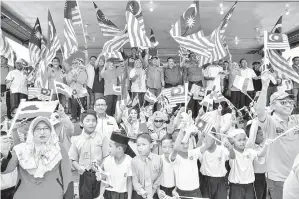  ??  ?? BUNG bersama para pemimpin dan pelajar sekolah mengibar Jalur Gemilang.