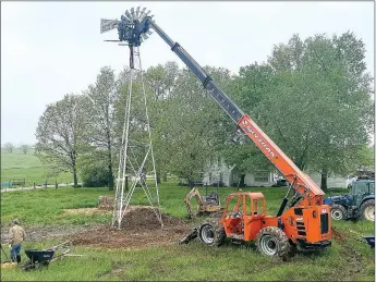  ?? TIMES photograph by Annette Beard ?? Todd Crowder and employees of Crowder Constructi­on work to prepare footing and place a historic windmill on a historic farm north of Pea Ridge. The windmill, which had been on the old Vic Miller farm, was removed from the subdivisio­n in order to save it from destructio­n, the new owner said.