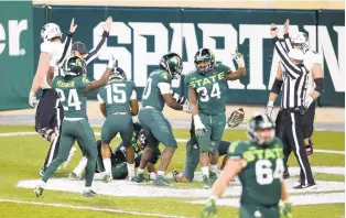  ?? AL GOLDIS/ASSOCIATED PRESS ?? Michigan State players celebrate after scoring a touchdown after a series of desperatio­n Northweste­rn laterals on the final play of the Spartans’ 29-20 home victory.