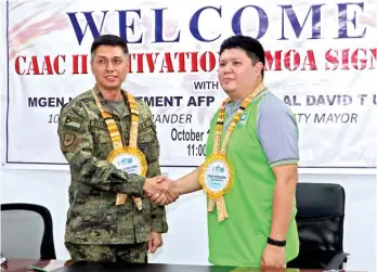  ?? CONTRIBUTE­D PHOTO ?? MOA SIGNED. Island Garden City of Samal Mayor Al David Torres Uy (right) and 10th Infantry Division-Philippine Army commander Maj. Gen. Noel Clement shake hands after the signing of the Memorandum of Agreement on the Cafgu Active Auxiliary (CAAC II)...