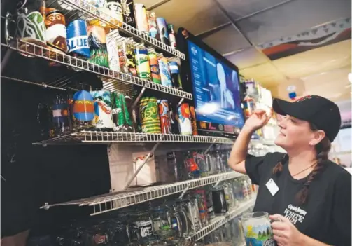  ?? Joe Amon, The Denver Post ?? Pepperoni’s Pizzeria and Bar supervisor Dani Dresch searches for a mug at the watering hole, which is located in the basement of the lodge at the base of Mary Jane at Winter Park Resort. Winter Park likes to bill the “mug club” as the state’s largest.