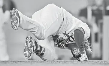  ?? Mark J. Terrill Associated Press ?? JUSTIN TURNER of the Dodgers crumples after being struck on the left hand by a pitch from Colorado’s Kyle Freeland in the fifth inning. Turner remained in the game and drove in a run in the ninth.