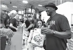  ?? Associated Press ?? ■ Charlotte Hornets owner Michael Jordan, right, loads boxes with goods for Hurricane Florence victims as he makes an appearance Friday at Second Harvest Food Bank of Metrolina in Charlotte, N.C. The Hornets NBA basketball team packed food boxes as part of hurricane relief efforts.