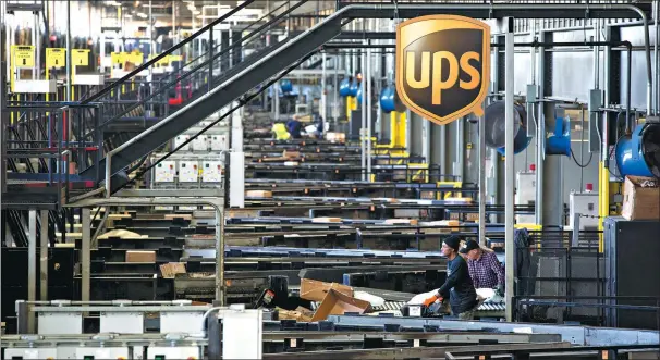  ?? BLOOMBERG VIA GETTY IMAGES ?? Employees sort packages at UPS’ Chicago area consolidat­ion hub in Hodgkins, Illinois, the United States.