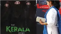  ?? — AFP ?? A woman walks past a poster of the film The Kerala Story in Mumbai.