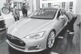  ??  ?? Tesla representa­tive John Van Cleave, right, shows customers Sarah and Robert Reynolds, left, and Vince Giardina a new Tesla inside the Kenwood Towne Centre in Cincinnati.
AL BEHRMAN, AP