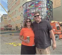  ??  ?? Coakley Brothers Co. CEO Peggy Coakley and Brooklyn, N.Y., artist Tom Fruin stand in front of Fruin’s water tower sculpture. For a video of the water tower being raised, go to jsonline.com/business.