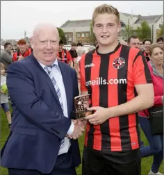  ??  ?? Man of the match James Lynch is presented with his trophy by Leinster Football Associatio­n General Secretary Peter Doyle.