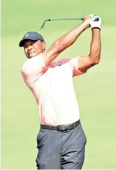  ?? — AFP photo ?? Tiger Woods of the United States plays a shot on the 16th hole during the first round of the TOUR Championsh­ip at East Lake Golf Club on September 20, 2018 in Atlanta, Georgia.