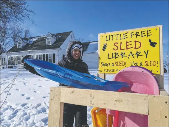  ??  ?? Jace Prohaska, 9, of Kansas City, Mo., borrows a sled from the Little Free Sled Library in Ventura, Iowa. He and his brother spent hours at the sledding hill at Lynne Lorenzen Park this past weekend. (Globe-Gazette/Ashley Stewart)