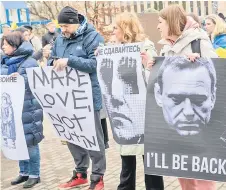  ?? ?? People hold signs while protesting in Riga during the Russian presidenti­al election.