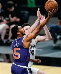  ??  ?? Drew Eubanks can’t keep the Suns’ Cameron Payne from getting to the hoop in Saturday’s loss, the Spurs’ worst of the season.