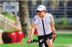  ?? AP ?? Wheels of change Mercedes driver Nico Rosberg of Germany rides a bike in the paddock at the Formula One Bahrain Internatio­nal Circuit.