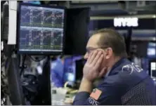  ?? RICHARD DREW — THE ASSOCIATED PRESS FILE ?? In this Wednesday file photo, specialist Anthony Matesic works on the floor of the New York Stock Exchange. The year’s run to a record for the stock market has been one of the least eventful in decades. But don’t get lulled: Many profession­al investors expect a bumpier ride ahead.