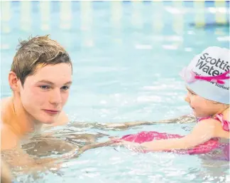  ??  ?? Making a splash Scottish Olympic Swimmer, Duncan Scott, interactin­g with young swimmers as part of the Learn to Swim initiative, which is helping EK youngsters become better in the pool