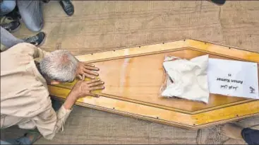  ?? AP ?? A relative pays his respects to one of those killed in Mosul, Iraq, nearly a year ago, in Dharamsala on Tuesday