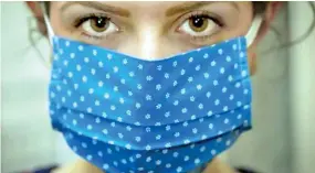  ??  ?? A cloth face-mask reduces — but does not eliminate — the spread of respirator­y droplets when the wearer breathes, talks, coughs or sneezes.