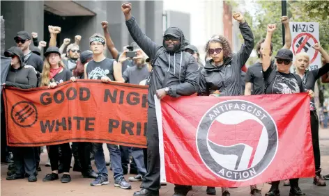  ??  ?? Un grupo con atuendos antifascis­tas marchó ayer en Downtown Mall, antes del primer aniversari­o de las protestas de Charlottes­ville.