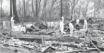  ??  ?? Volunteer rescue workers search for human remains in the rubble of burned homes in Paradise, Calif. ASSOCIATED PRESS