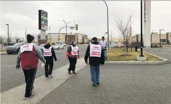  ?? ALEX MACPHERSON ?? Members of United Food and Commercial Workers Local 1400, including union president Norm Neault, walk a picket line outside a Saskatoon Co-op gas bar in the Blairmore neighbourh­ood on Thursday.