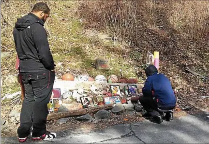  ?? DIANE PINEIRO-ZUCKER — DAILY FREEMAN ?? B.J. Williams, left, and Khaalid Alexander pay their respects Thursday at a makeshift memorial on Dock Street in the village of Saugerties to the four men who died in an August 2015car crash at the site.