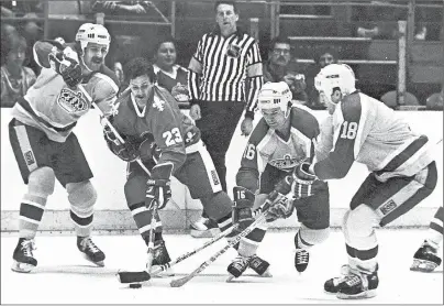  ?? CP PHOTO ?? QJacques Richard, (23) of the Quebec Nordiques, is surrounded by the Los Angeles Kings’ Charlie Simmer (11), Marcel Dionne (16) and Dave Taylor (18) as they scramble for possession of the puck during first-period action at the Forum in Los Angeles, Calif. in March 1983. Sometimes when three players click on the same line, like Dionne, Simmer and Taylor, the unit becomes bigger than the sum of its parts.