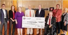  ?? (Special to The Commercial/Chris Cranford) ?? Tommy May (third from right) chairman of the Simmons First Foundation, and other officials present a $150,000 donation to The Nature Conservanc­y in Arkansas on Aug. 12.