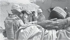  ?? TOM BROWN/ MARINE CORPS TIMES ?? U. S. Marines question a local farmer through an interprete­r on a civil engagement patrol in Bakwa, Afghanista­n, in March 2009.